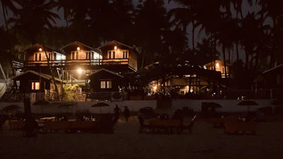 Cozy surf camp houses with warm lights glowing in the evening.