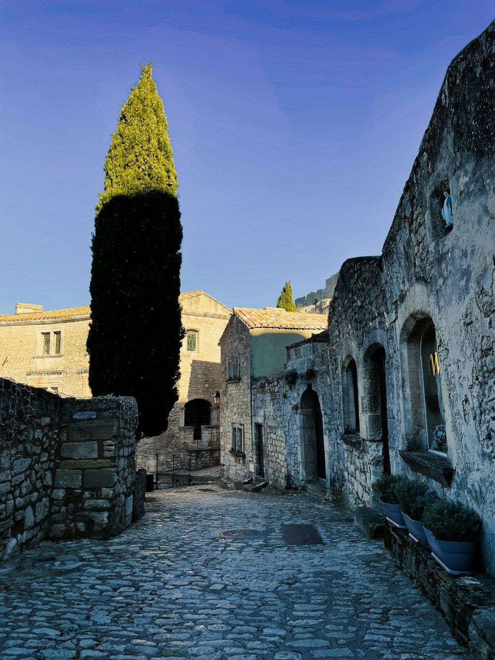 a cobblestone street with a stone building in the background