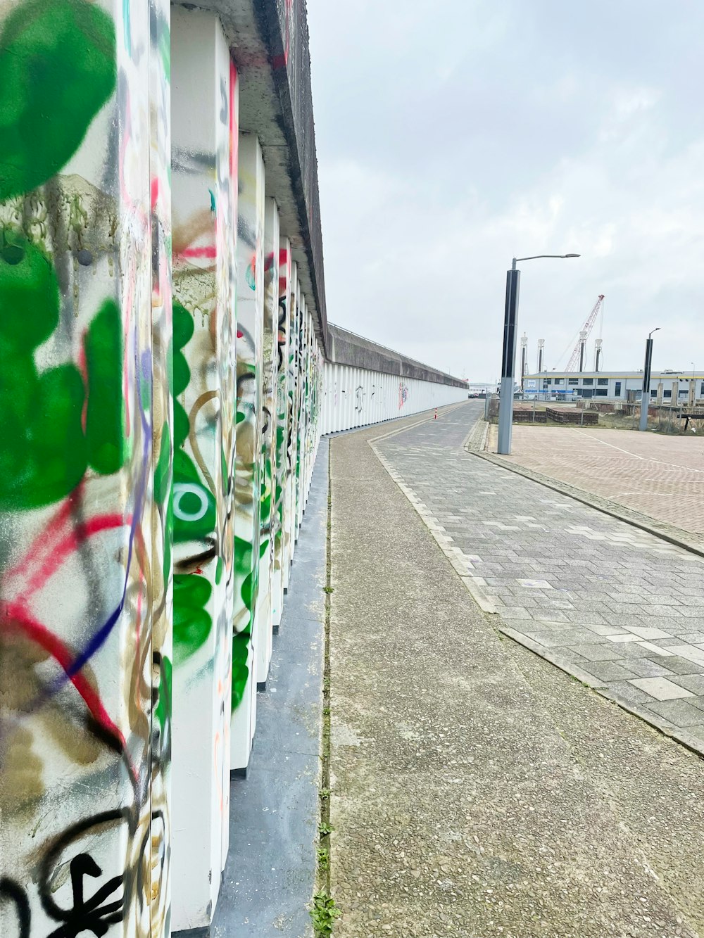 a wall covered in graffiti next to a street