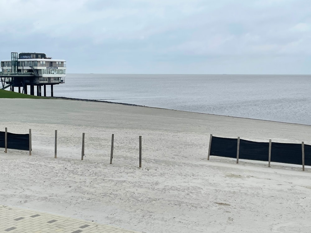 a building on a beach next to a body of water