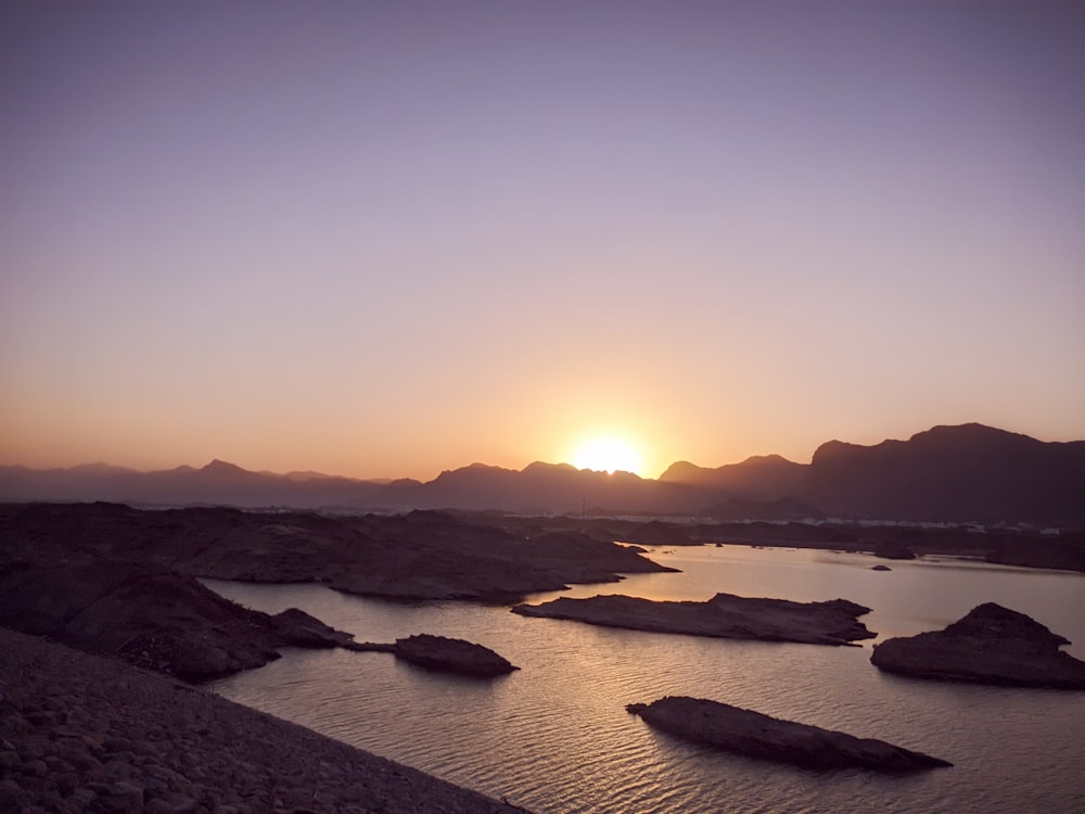 the sun is setting over a body of water