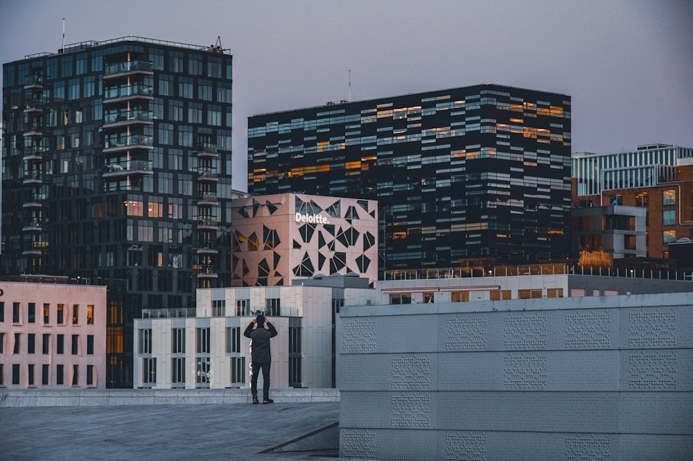 a man standing in front of a tall building