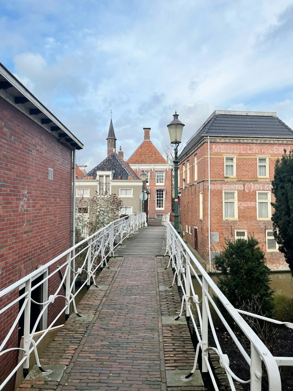 a walkway leading to a building with a clock tower in the background