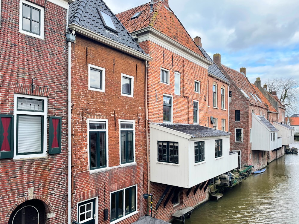 a row of brick buildings next to a body of water