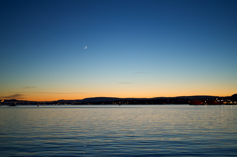 a body of water with a moon in the sky