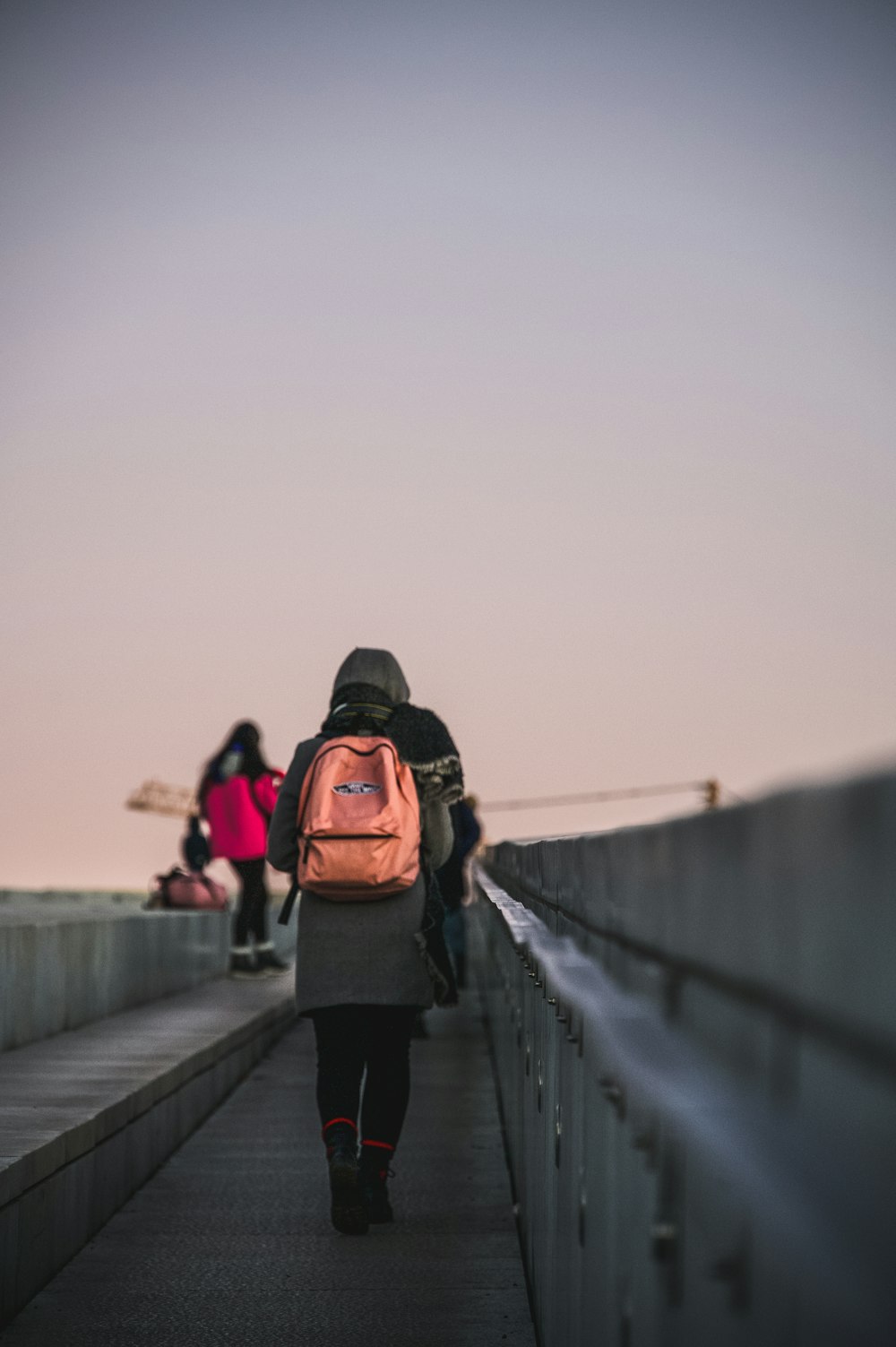 a person walking across a bridge with a backpack