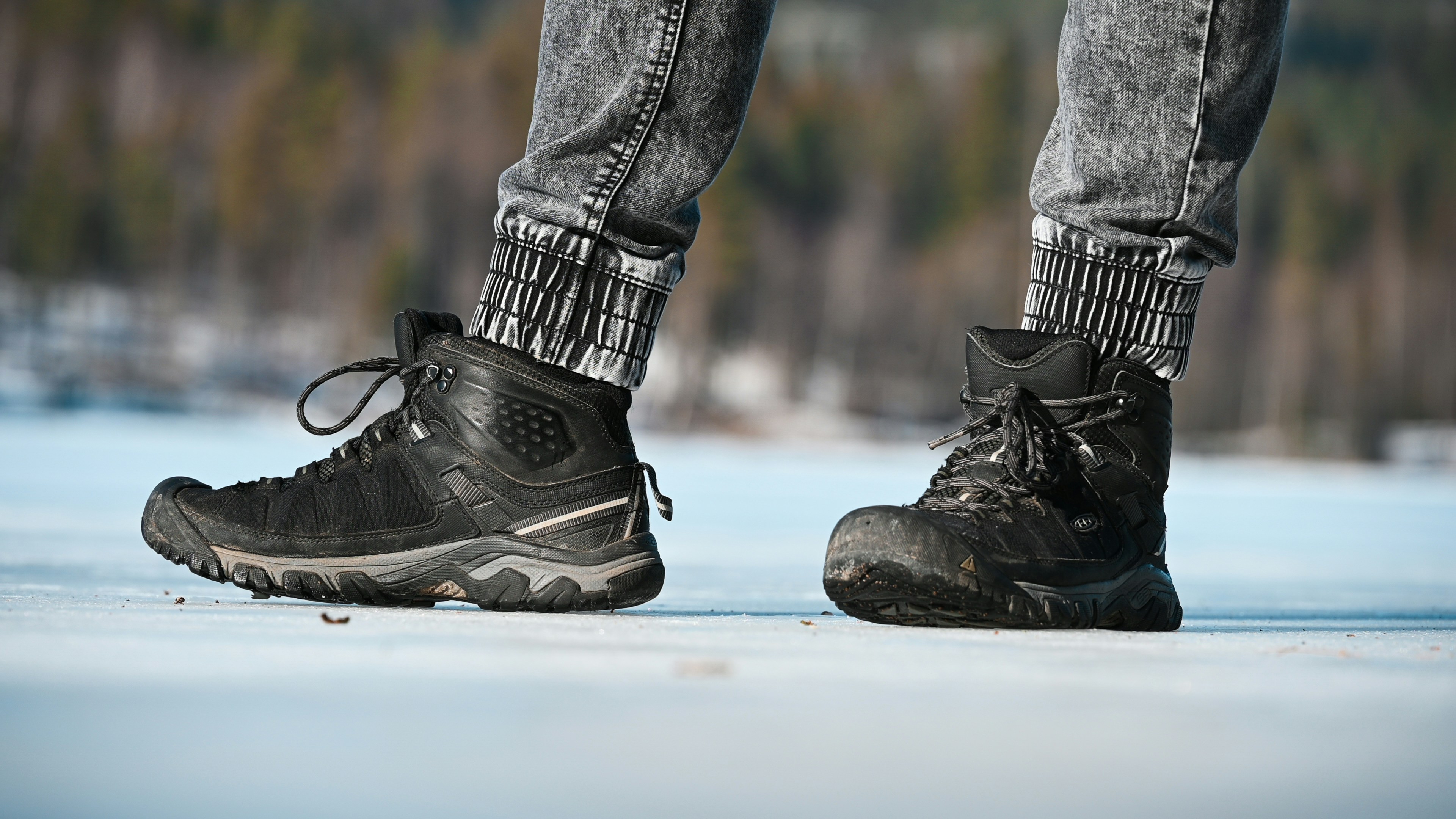a person standing on a snowy surface wearing black shoes
