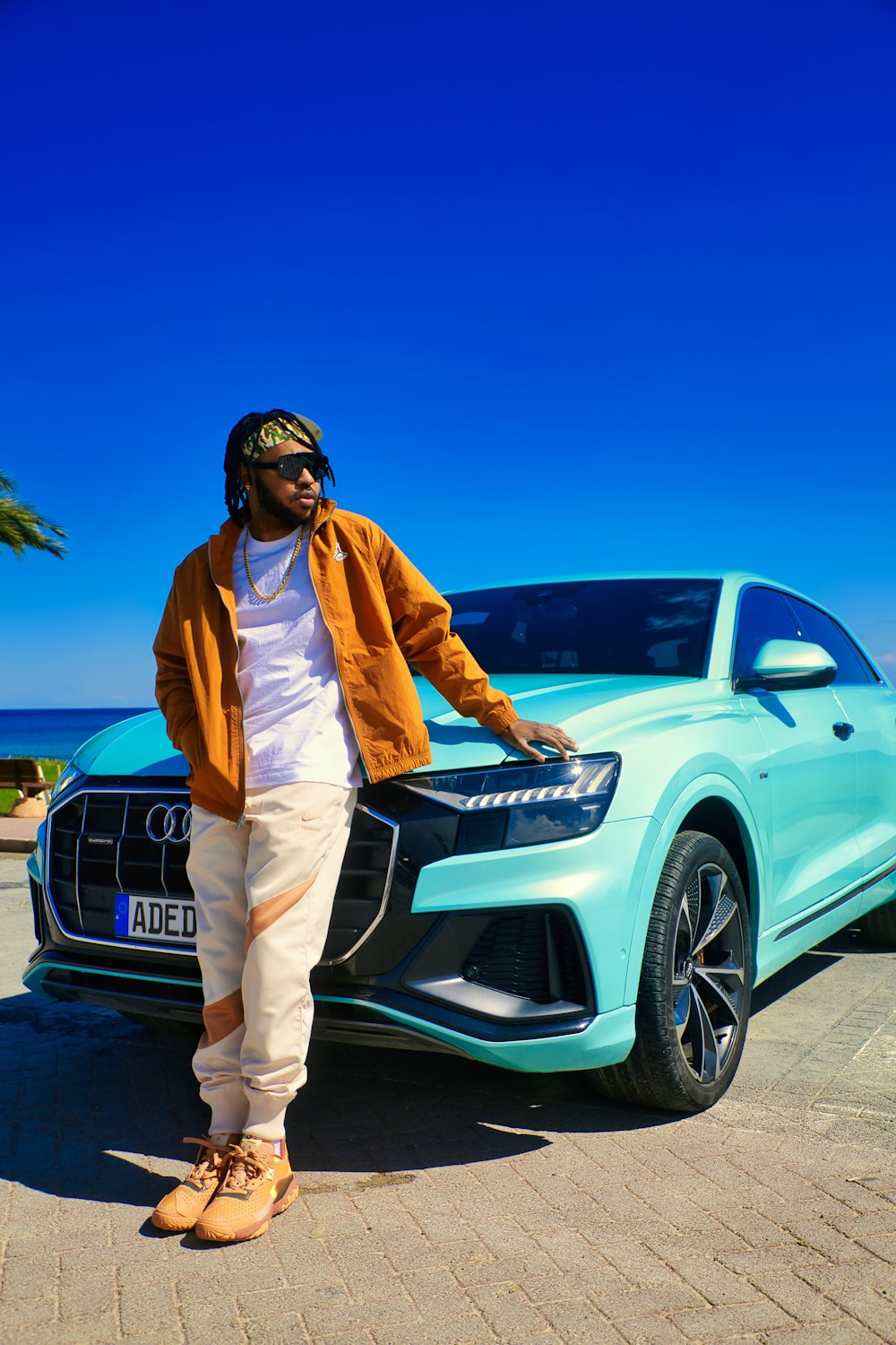 a man standing next to a blue car