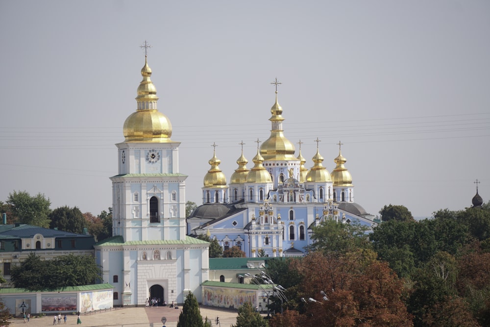 a large white and gold church with gold domes