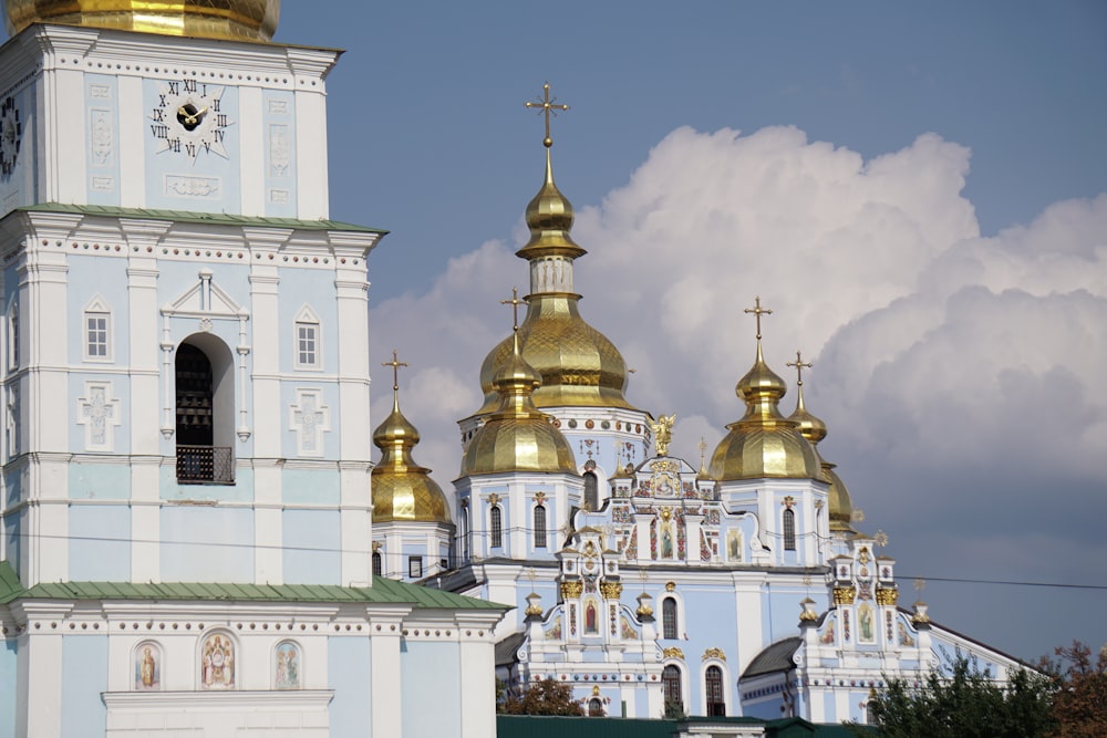 a large white and gold church with a clock tower