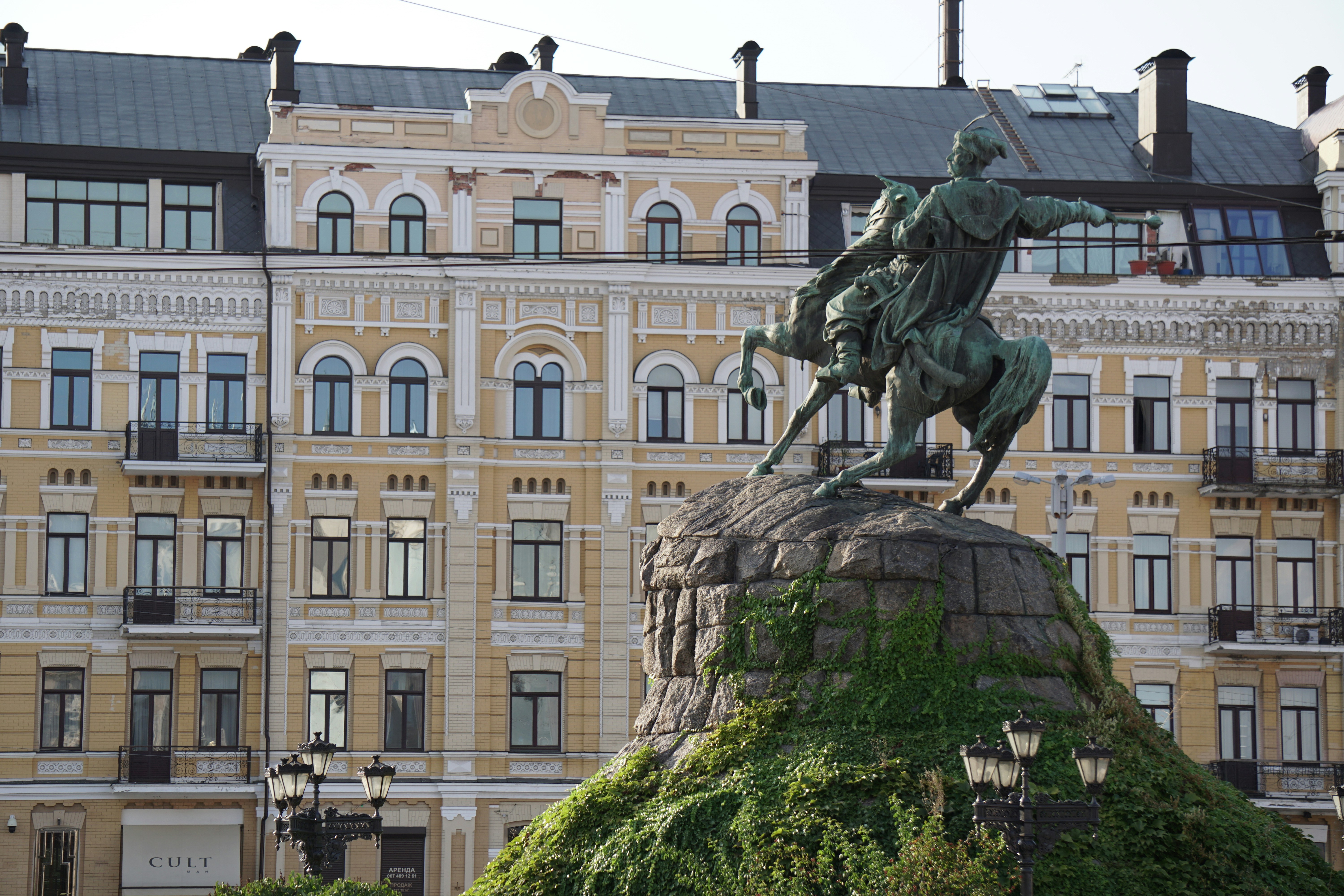 a statue of a man on a horse in front of a building