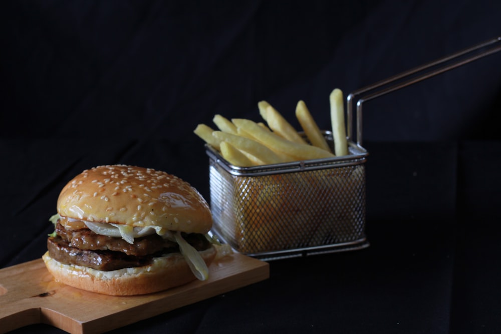 a hamburger and french fries on a cutting board