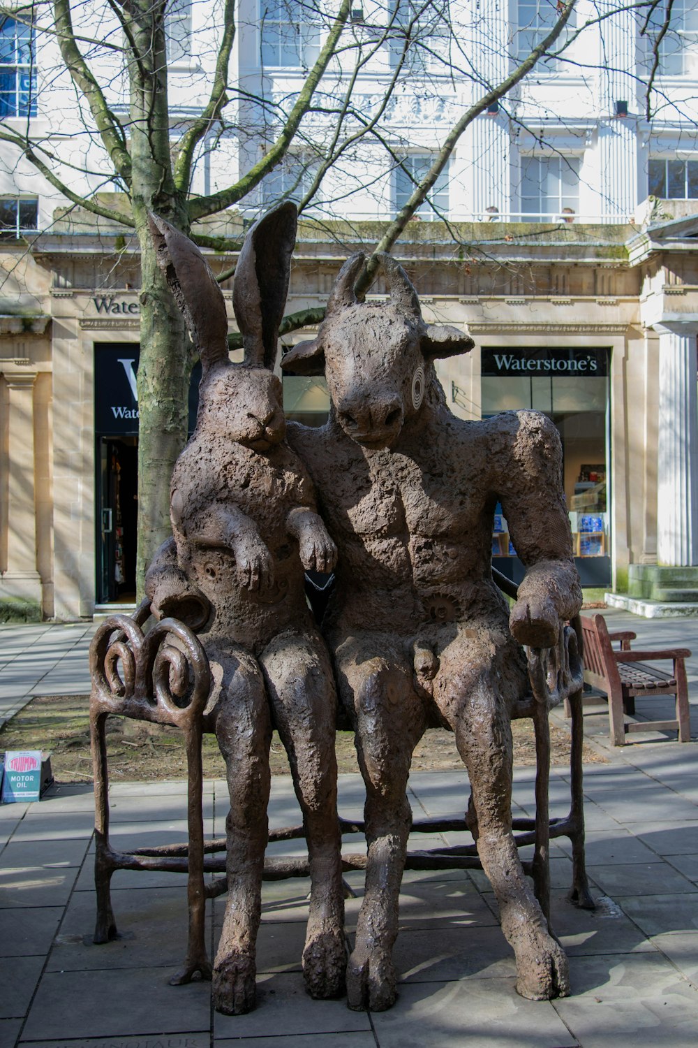 a couple of statues sitting on top of a bench