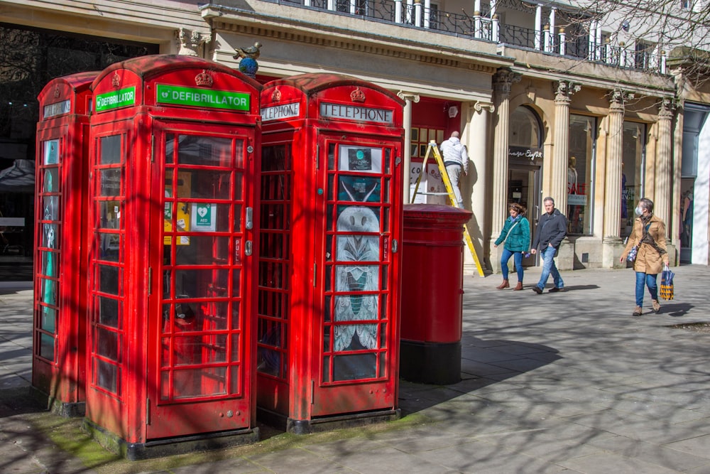 quelques cabines téléphoniques rouges assises sur le bord d’une route