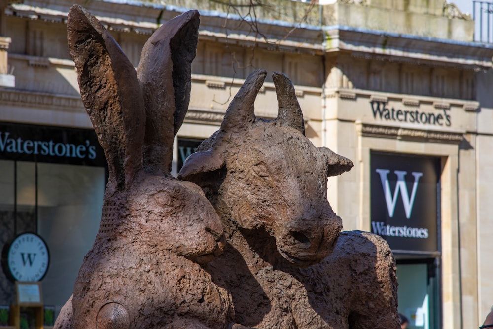 a statue of two rabbits in front of a building