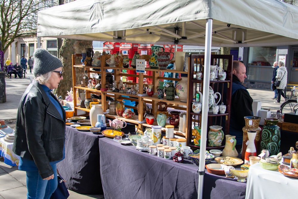 a woman standing in front of a table with a lot of items on it