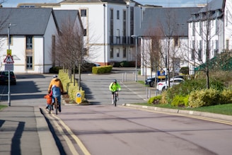 a couple of people riding bikes down a street