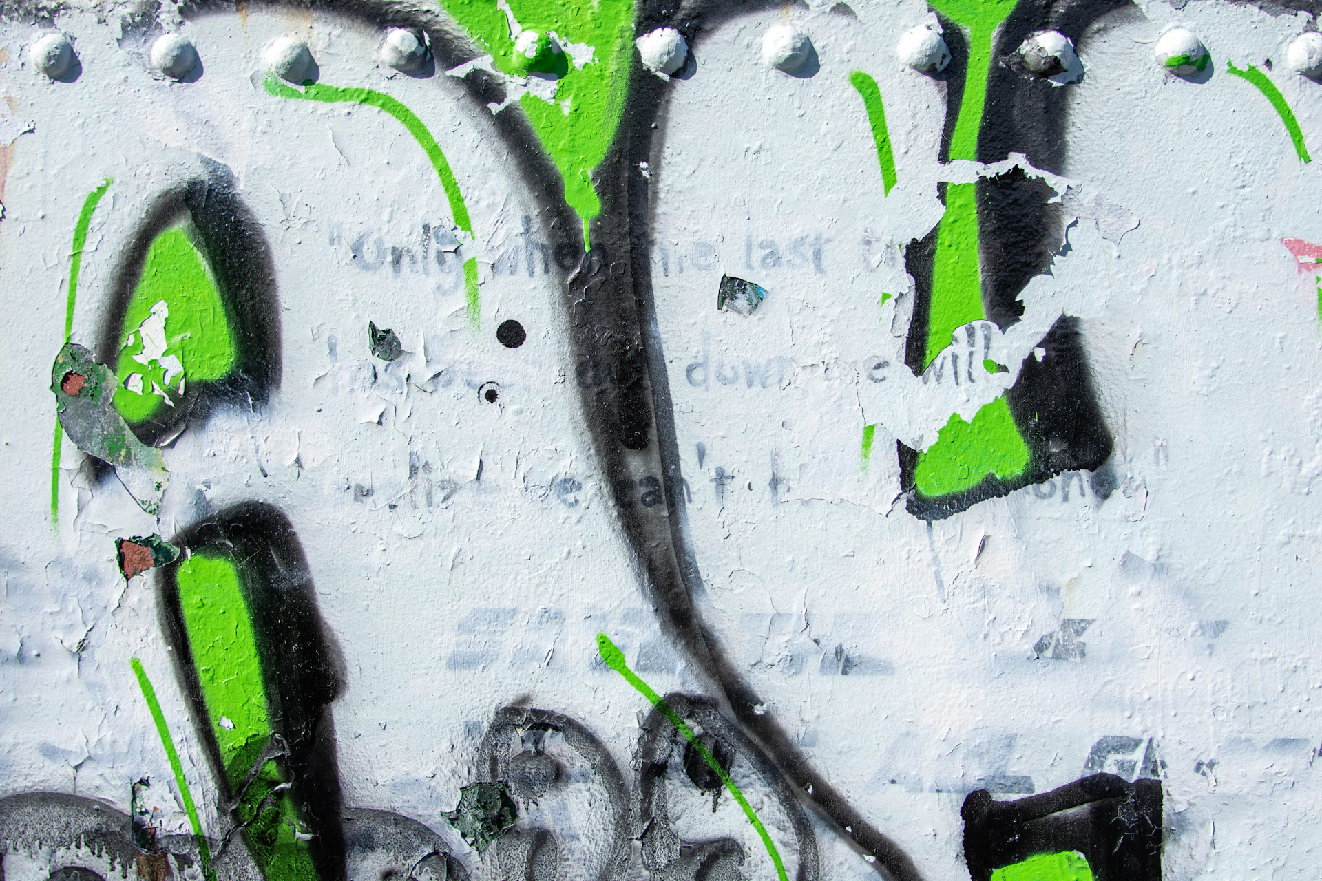 a painting of green and black paint on a white wall
