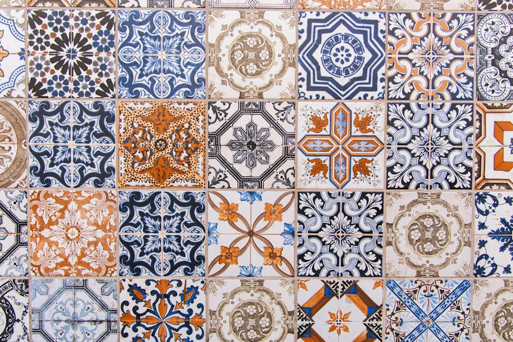 a close up of a tiled wall with different designs