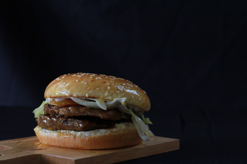 a hamburger sitting on top of a wooden cutting board