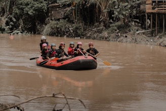 a group of people riding on the back of a raft down a river