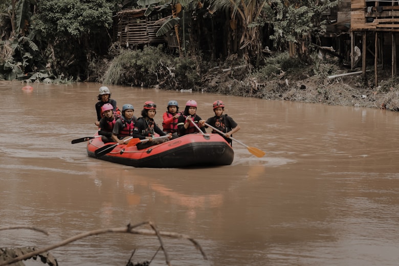 a group of people riding on the back of a raft down a river