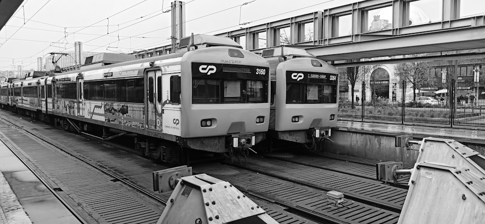 a black and white photo of two trains at a train station