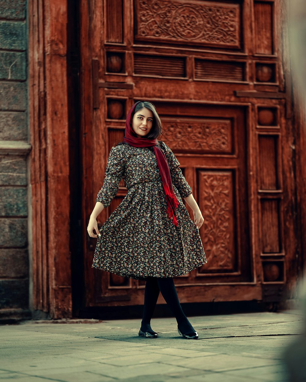 a woman standing in front of a wooden door