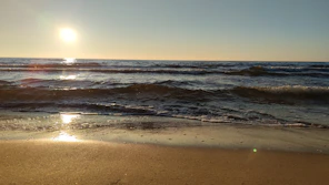 the sun is setting over the ocean waves