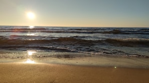 the sun is setting over the ocean waves