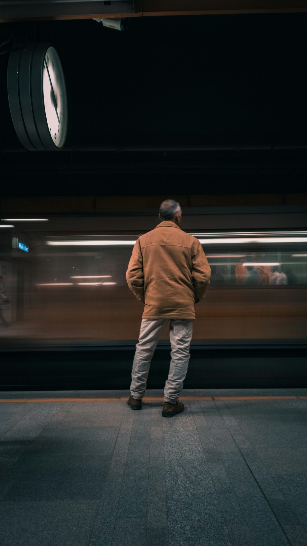 a man standing in front of a train at a train station