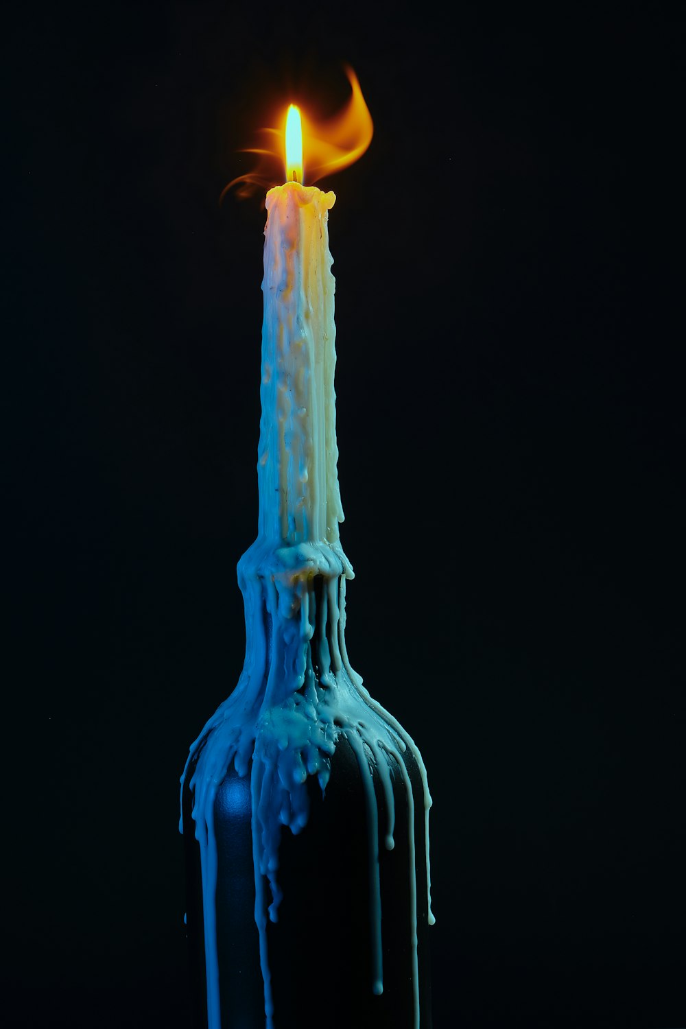 a lit candle in a bottle that is melting