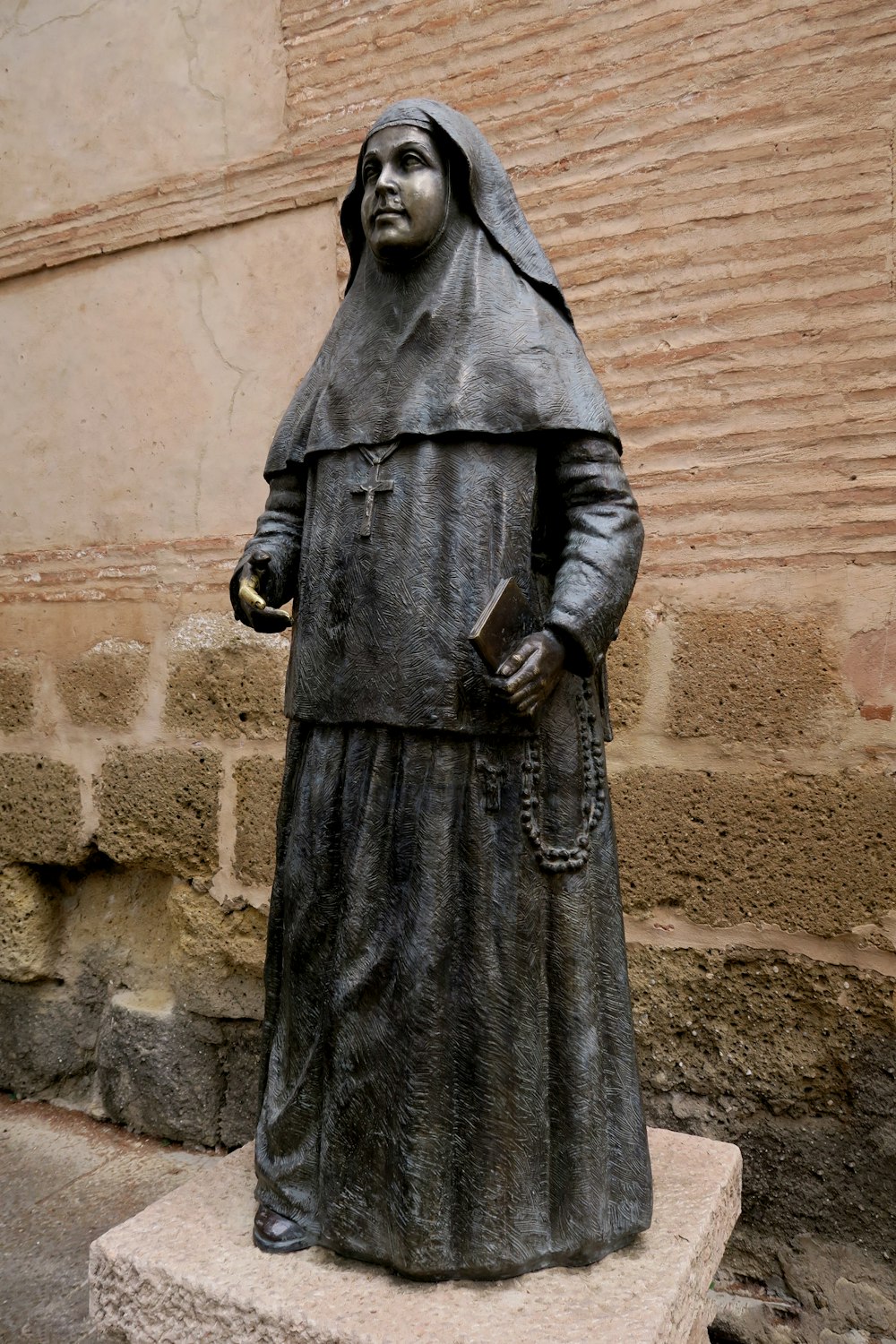 a statue of a nun in front of a building
