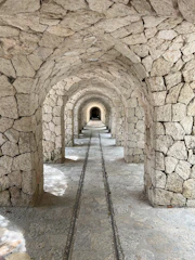 Andador de hotel en Xcaret que pasa debajo de techo de piedra con estilo arquitectónico