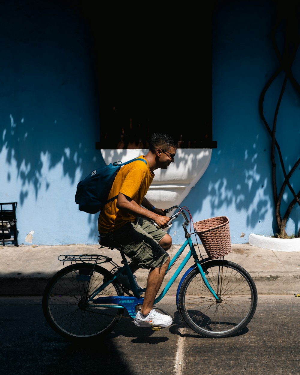 a man riding a blue bike down a street