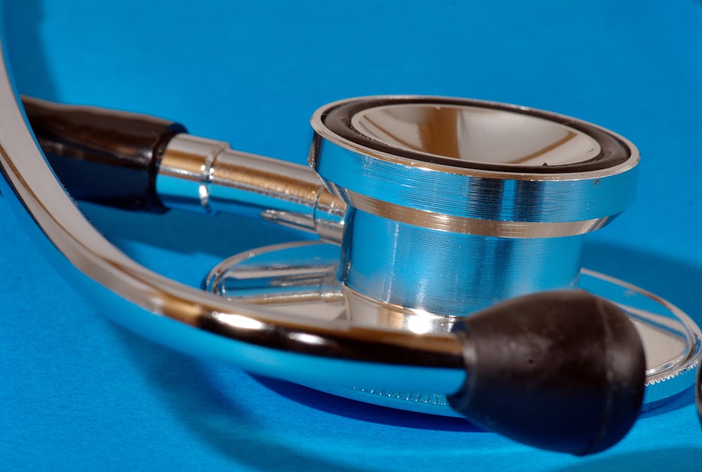 a medical stethoscope laying on a blue surface
