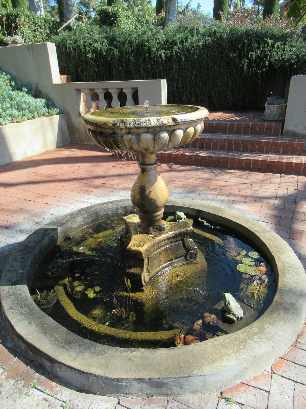 a water fountain in the middle of a brick walkway