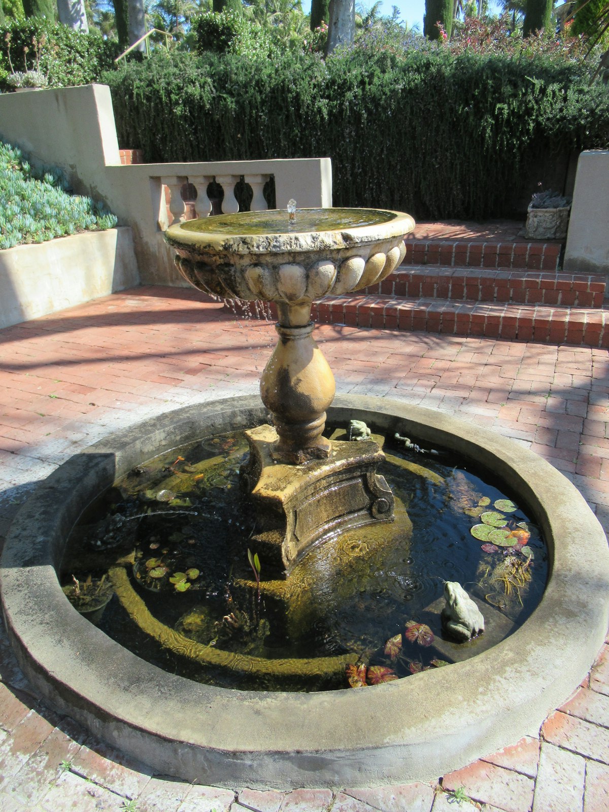 Mixed hardscape materials with brick walkway, stone elements, and landscape design