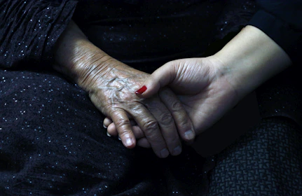 a woman's hands with red nail polish on them