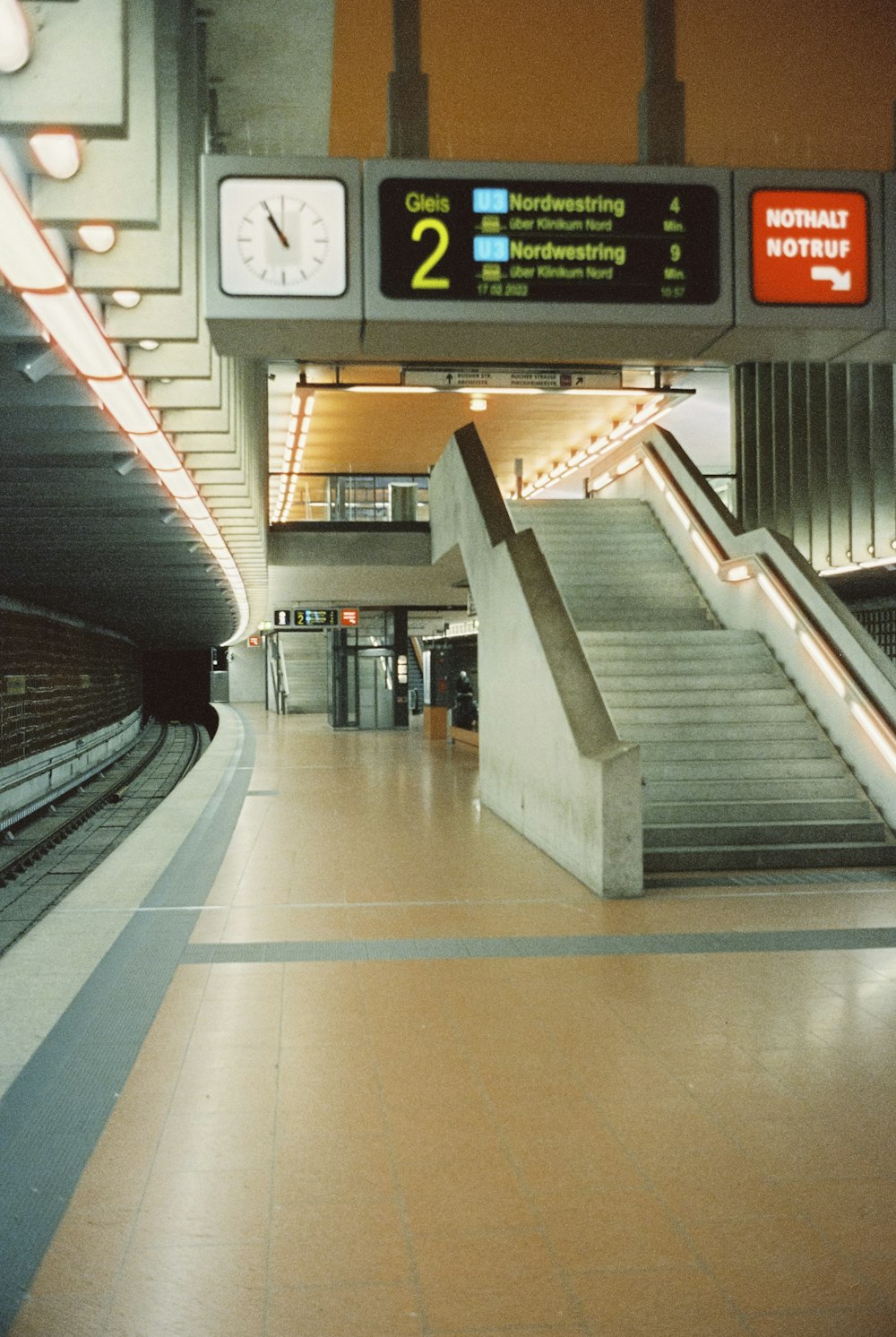 a subway station with a clock and stairs