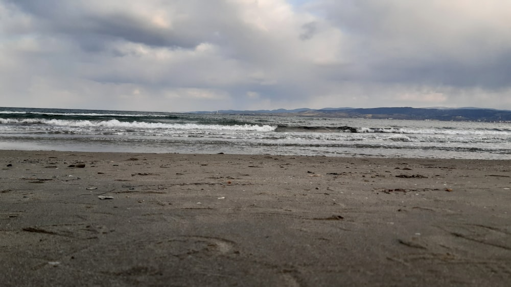 a sandy beach with waves coming in to shore