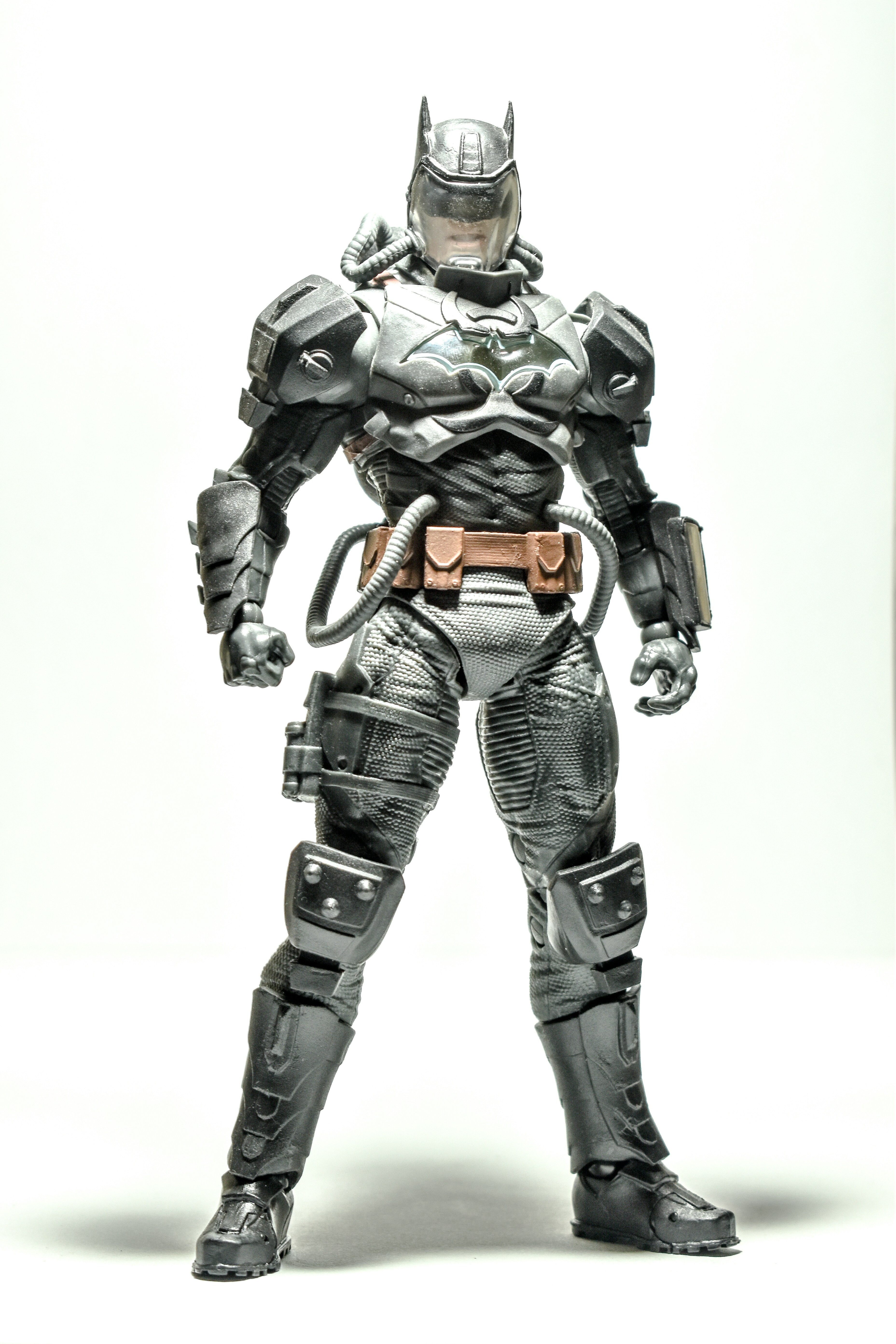 Batman action figure in dark grey and black armor with cape in shadowy cinematic black background display