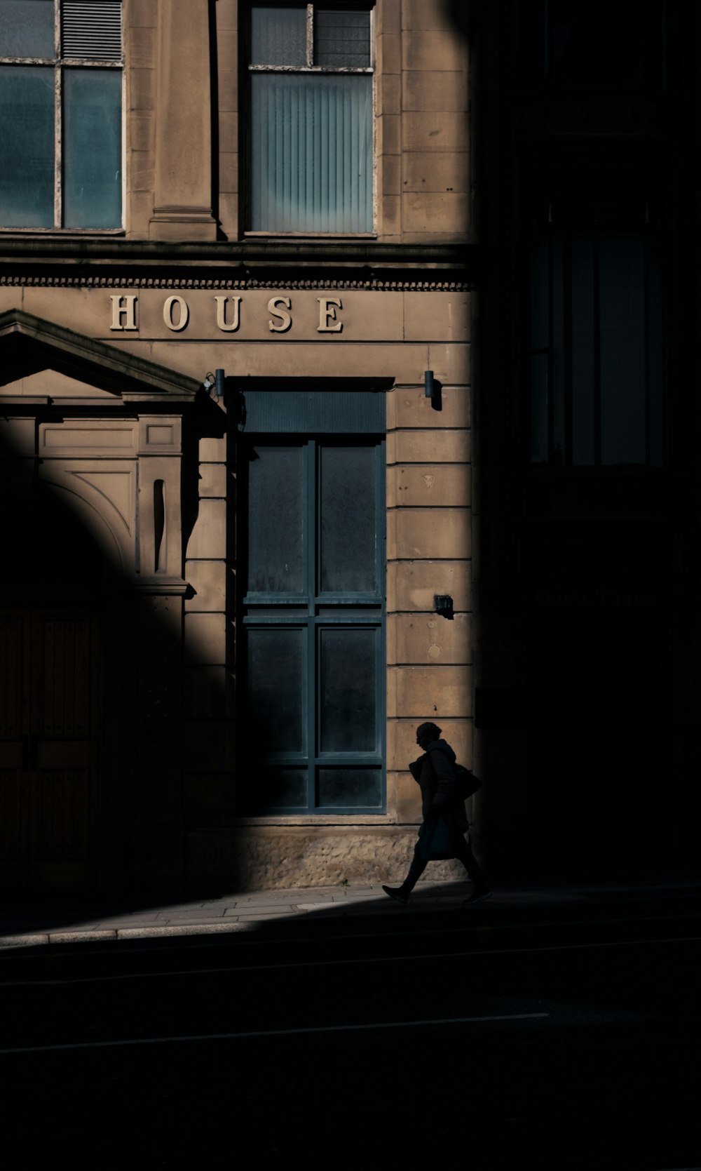 a person walking down a street in front of a building