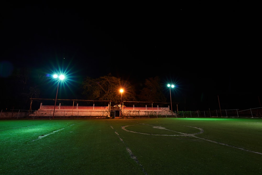 a soccer field at night with green lights