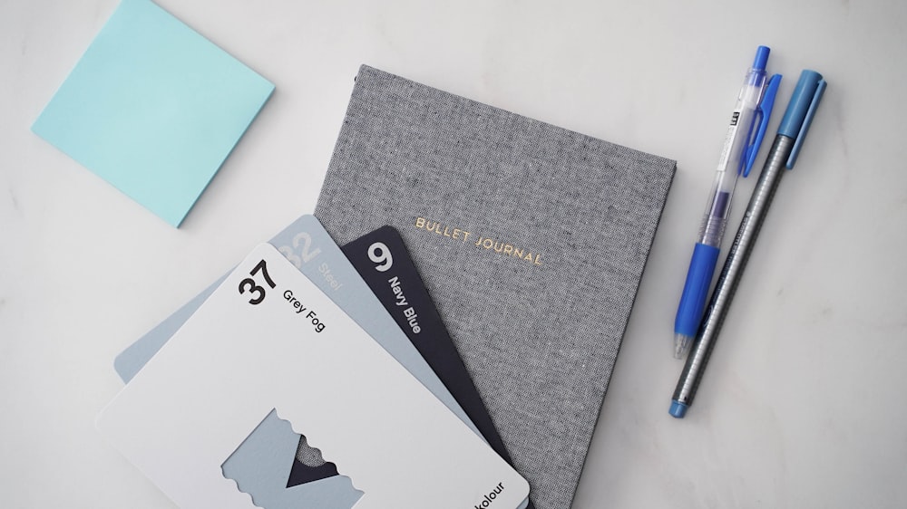 a notepad, pen, and envelope on a table