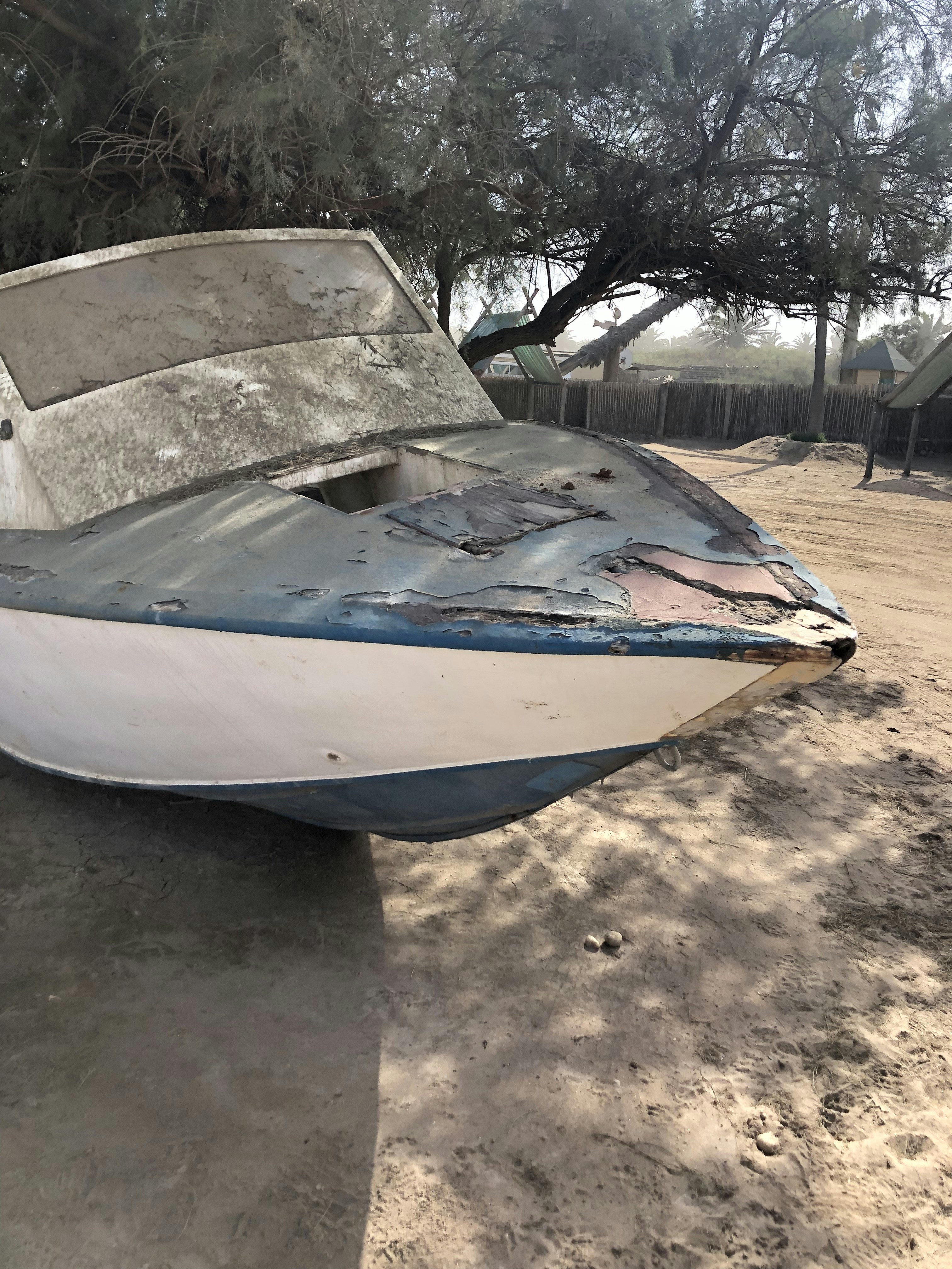 a boat sitting on top of a sandy beach