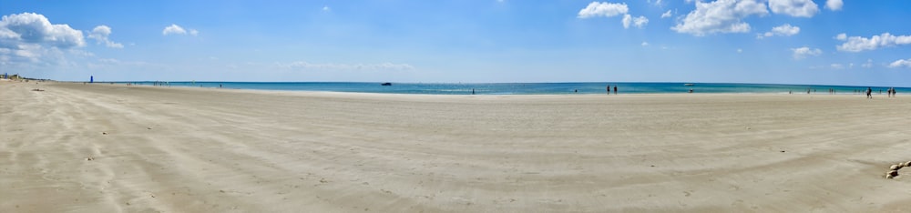 a sandy beach with people walking on it