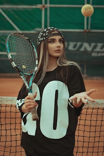a woman holding a tennis racquet on top of a tennis court