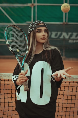 a woman holding a tennis racquet on top of a tennis court