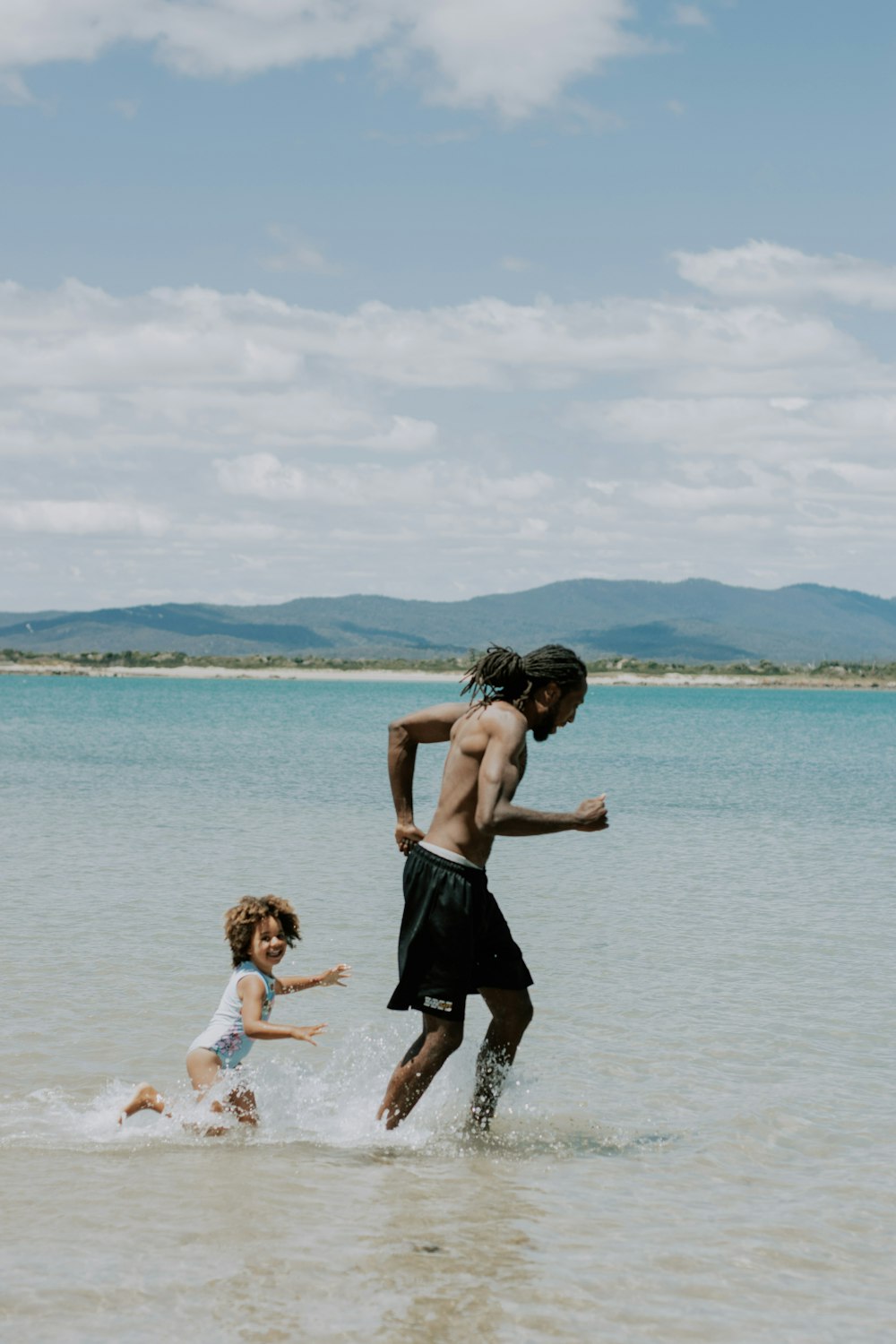 a man and a little girl playing in the water